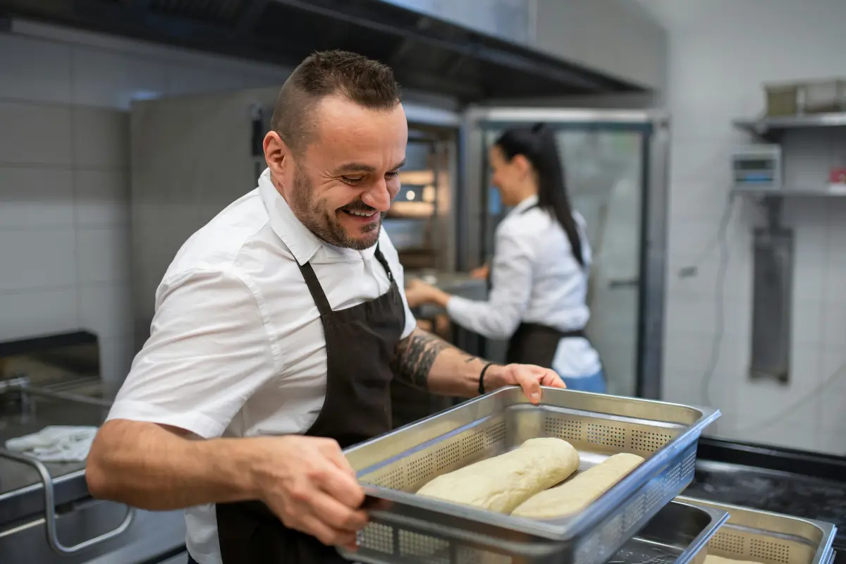 This image captures a moment of activity and positive interaction in a professional kitchen, featuring two staff members.