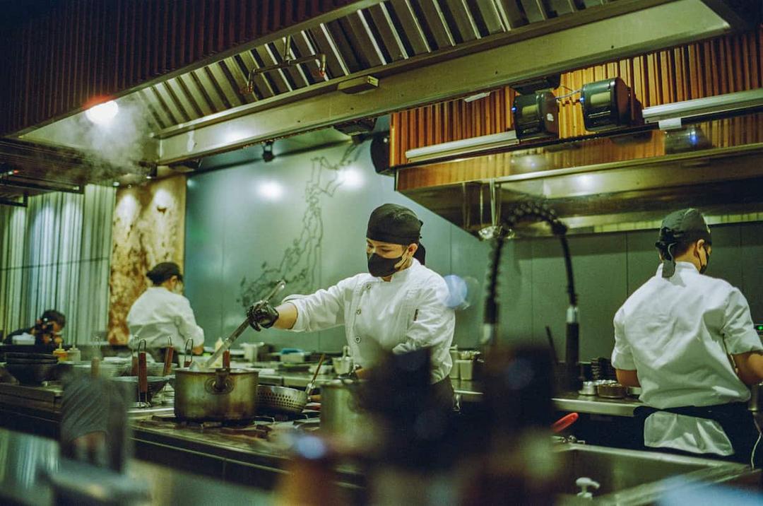 Photograph of a chef in a dark kitchen for catering.