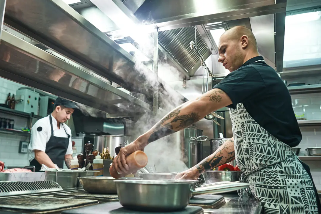 This is an image of two chefs working intensely in a professional kitchen.