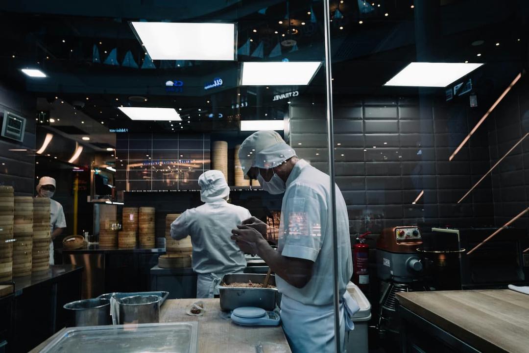 Chefs working in a sterile kitchen environment, highlighting the importance of a HACCP plan for commercial kitchens.