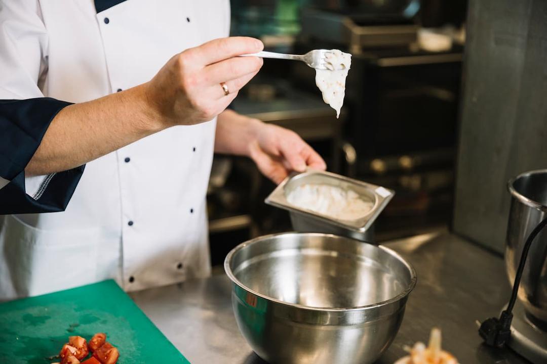 Chef preparing ingredients in a commercial kitchen, representing kitchen licensing requirements in New York City.